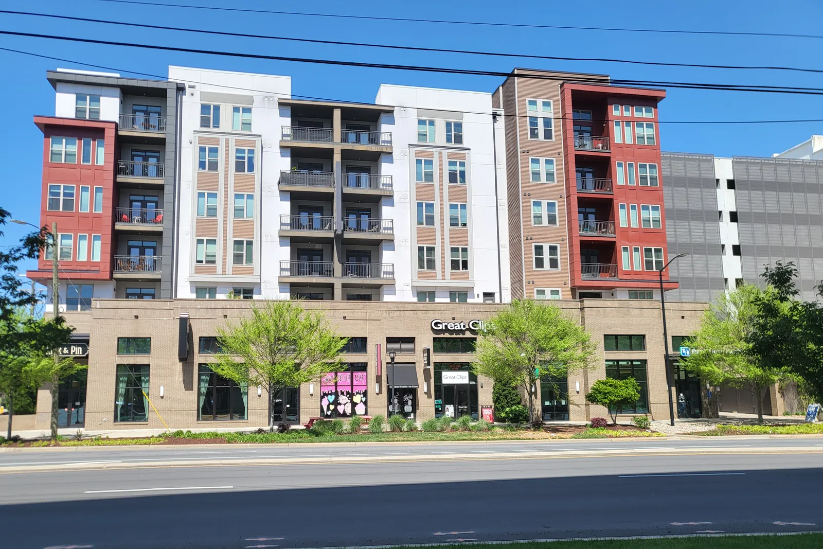 Mid-rise apartment buildings over ground-floor retail along a city street.