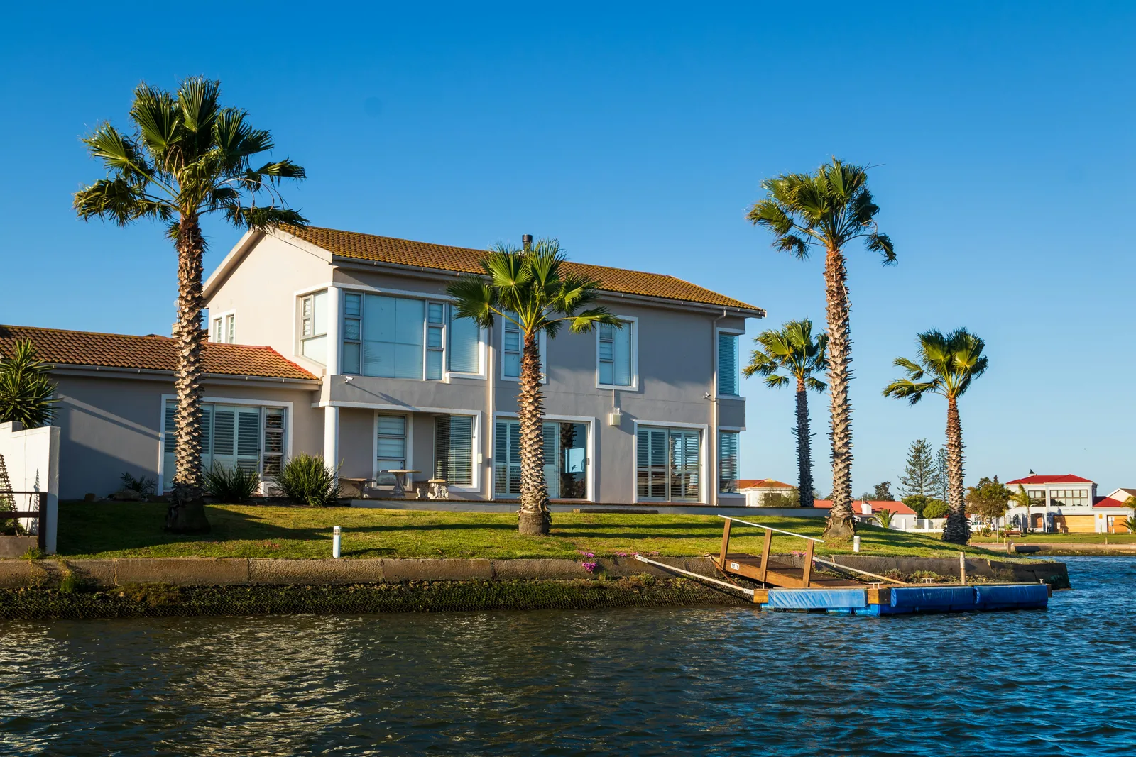 Waterfront vacation home with palm trees and a private dock.